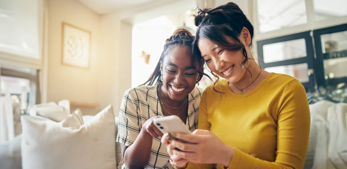 girls smiling and looking the phone