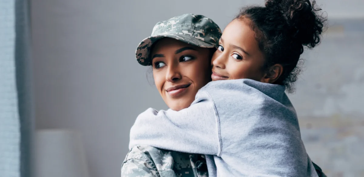 military with little girl hugging each other
