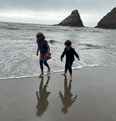 The silhouettes of two children running on a beach