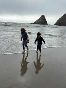 The silhouettes of two children running on a beach